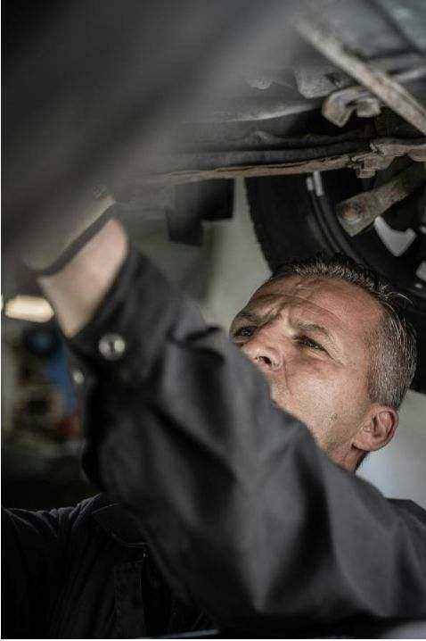 Technician inspecting car engine at roadside